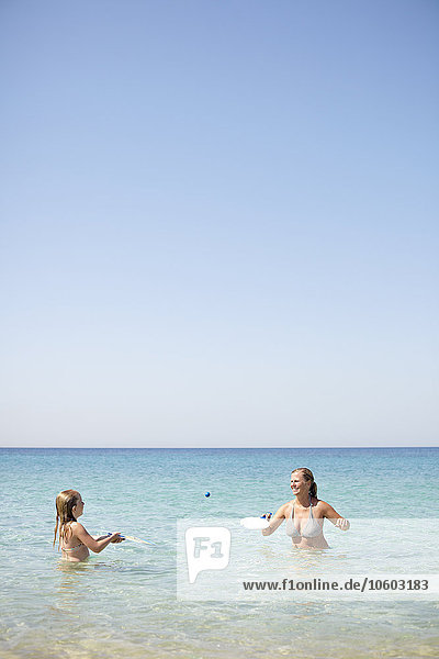 Mutter mit Tochter spielt im Meer