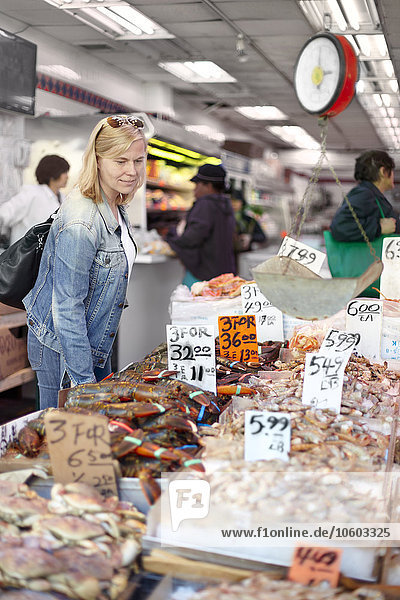 Frau sieht sich Meeresfrüchte auf dem Markt an