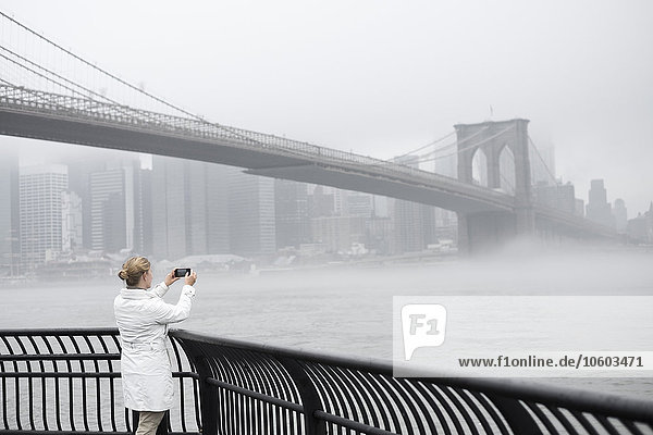 Woman taking picture of bridge