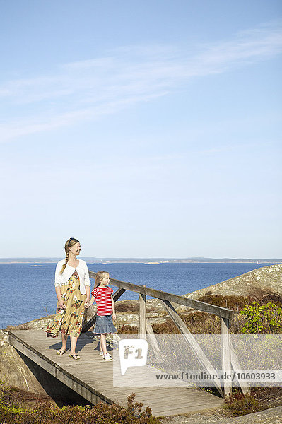 Mutter mit Tochter bei einem Spaziergang am Meer