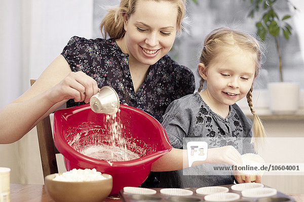 Mutter mit Tochter bei der Herstellung von Cupcakes
