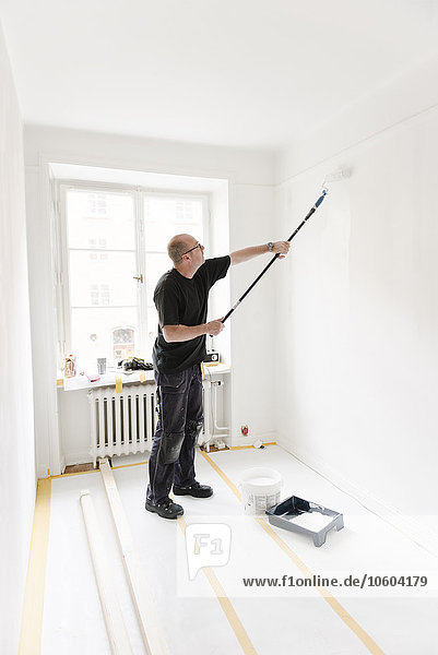 Mann malt Zimmer