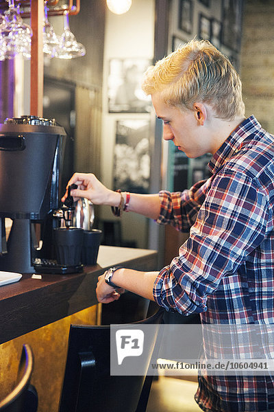 Junger Mann trinkt Kaffee in einem Cafe