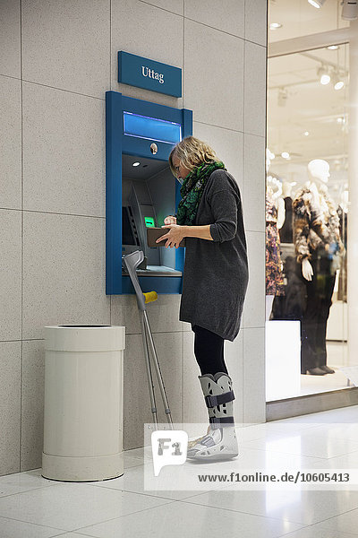 Frau mit Geldautomat
