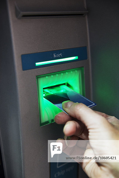 Hand setzen Bankkarte in Geldautomat