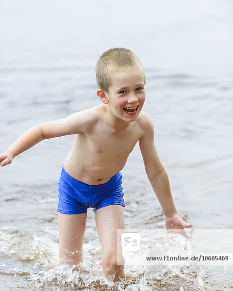Lachender Junge spielt im Wasser