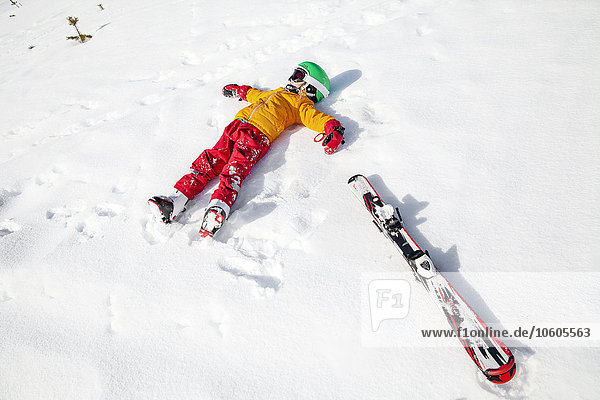Kind im Schnee mit Snowboard