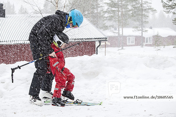 Vater mit Kind beim gemeinsamen Skifahren