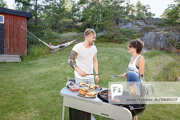 Couple preparing food on barbecue
