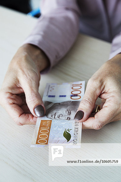 Frau hält schwedische Kronen-Banknote