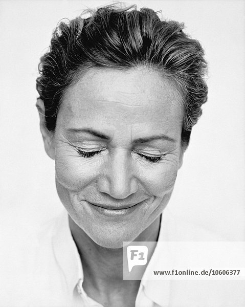 Porträt einer lächelnden Frau mit geschlossenen Augen.