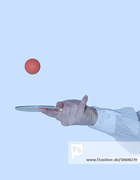 Ping-Pong-Ball mit der Hand auf dem Paddel hüpfend