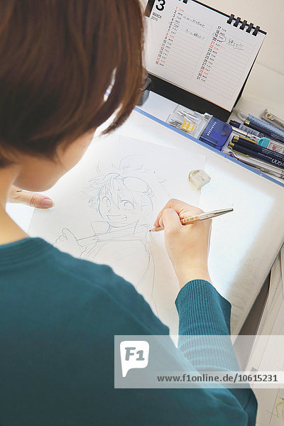 Japanischer Manga-Zeichner bei der Arbeit im Atelier