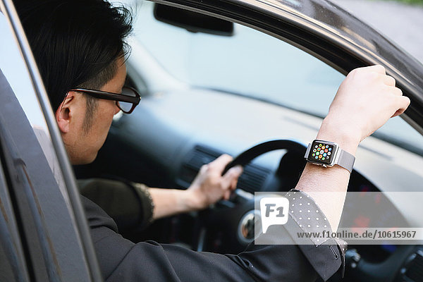 Japanese man in the car with wearable smart watch