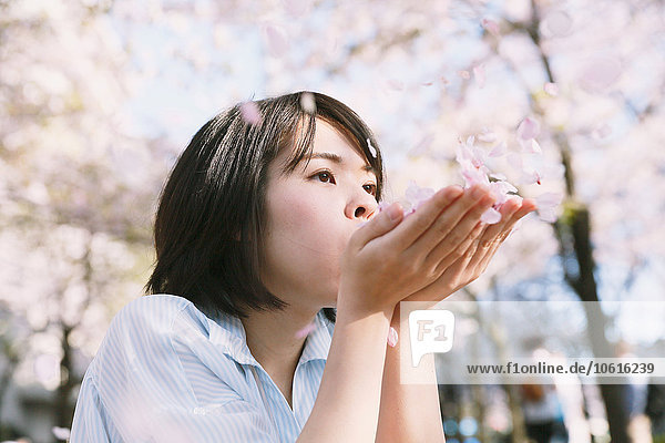 Junge Japanerin erfreut sich an blühenden Kirschblüten in Tokio