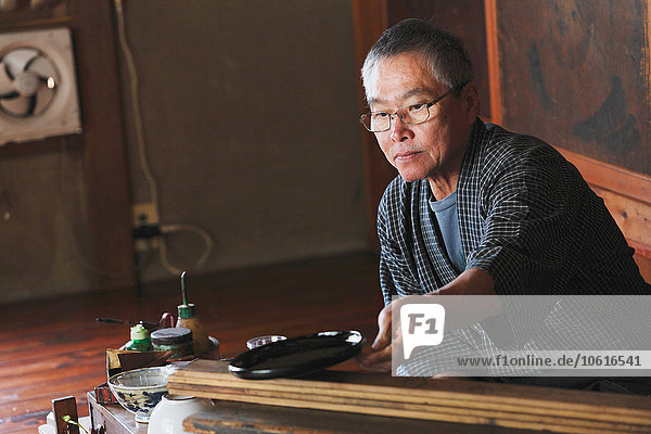 Japanese lacquer artisan working in the studio