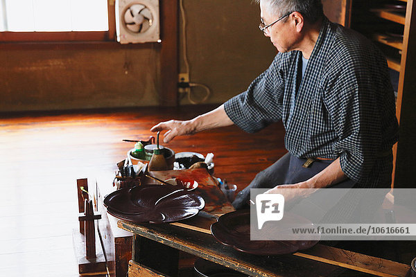 Japanischer Lackkunsthandwerker bei der Arbeit im Atelier