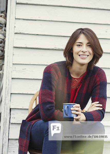 Portrait lächelnde brünette Frau beim Kaffeetrinken im Freien