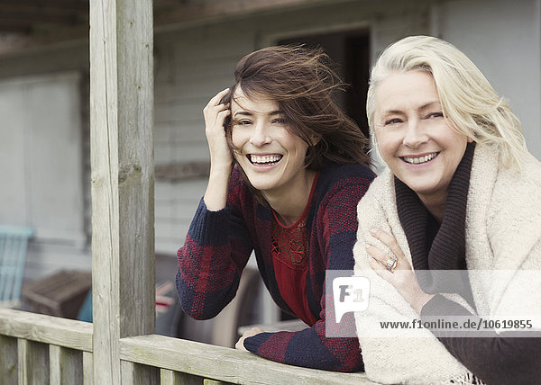 Portrait smiling mother and daughter on windy porch