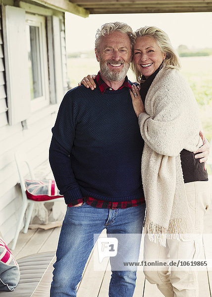 Portrait smiling senior couple hugging on porch