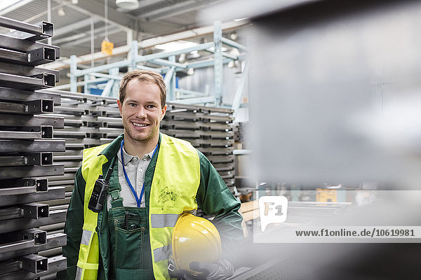 Portrait smiling worker in protective workwear in steel factory