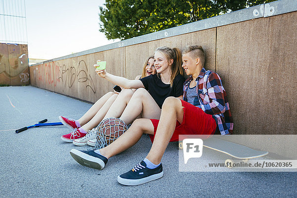 Three teenagers outdoors taking a selfie