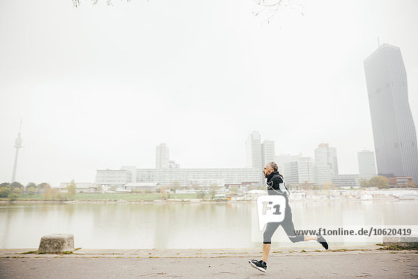 Österreich  Wien  Mann joggen auf der Donauinsel