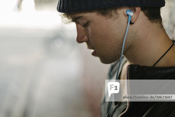 Profil des jungen Mannes  der Musik mit Kopfhörern hört