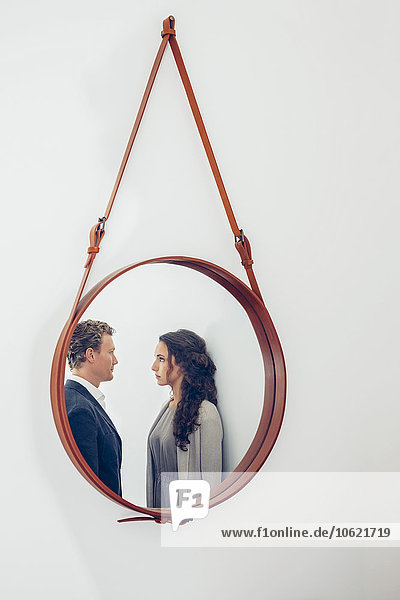 Spiegelung des Paares in einem an der Wand hängenden Spiegel