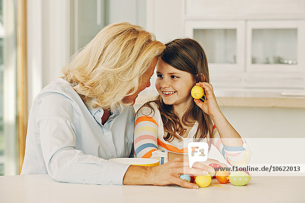 Smiling grandmother with granddaughter at table