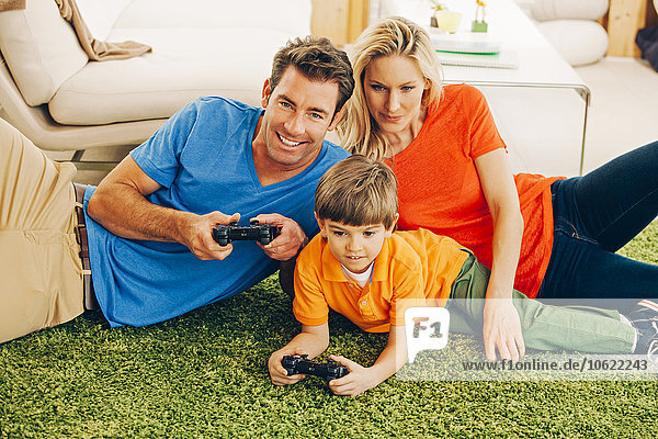 Family of three playing video game in living room