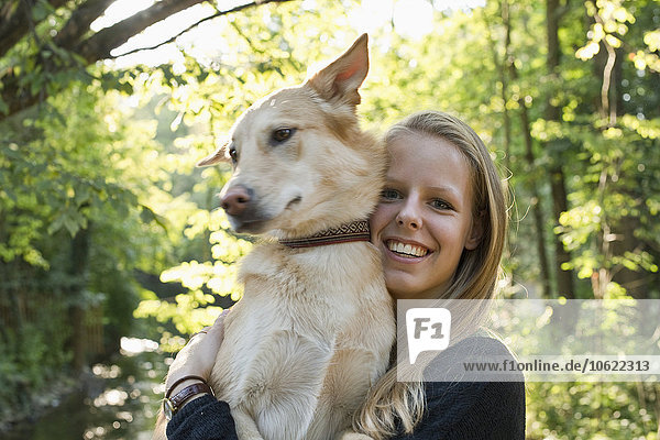Portrait of smiling young woman holding her dog