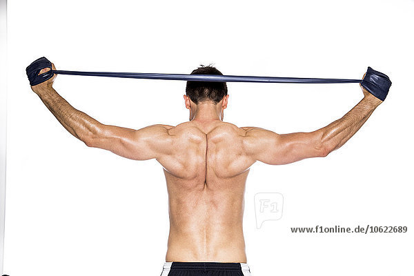 Rückansicht des hemdlosen Muskeltrainings mit Fitnessband vor weißem Hintergrund