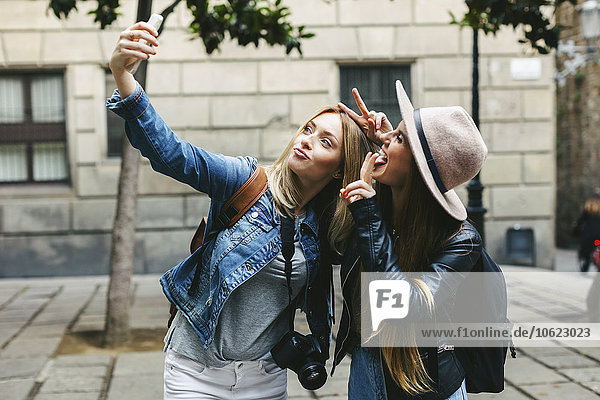 Zwei verspielte junge Frauen  die einen Selfie nehmen.
