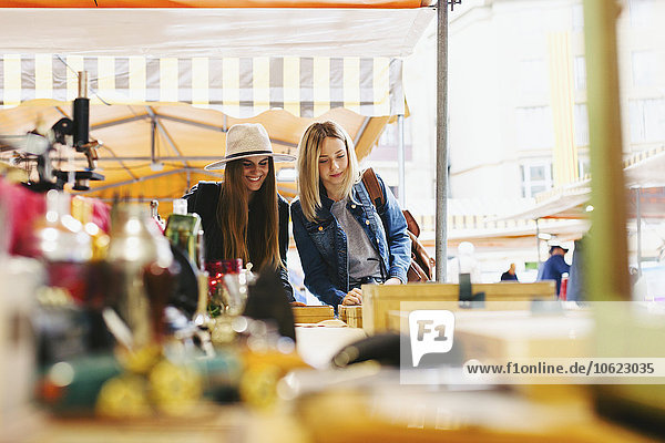 Zwei junge Frauen an einem Stand auf dem Flohmarkt