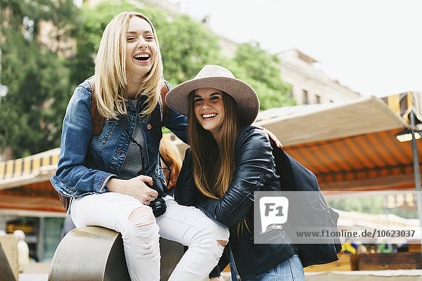 Spanien  Barcelona  zwei glückliche junge Frauen in der Stadt