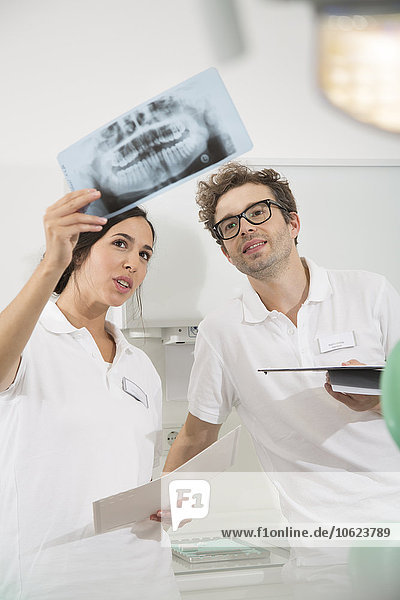 Two dentists in dental surgery discussing x-ray image