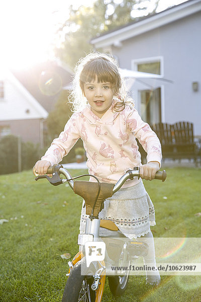 Mädchen auf dem Fahrrad im Garten
