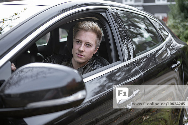 Young man in car looking out of window