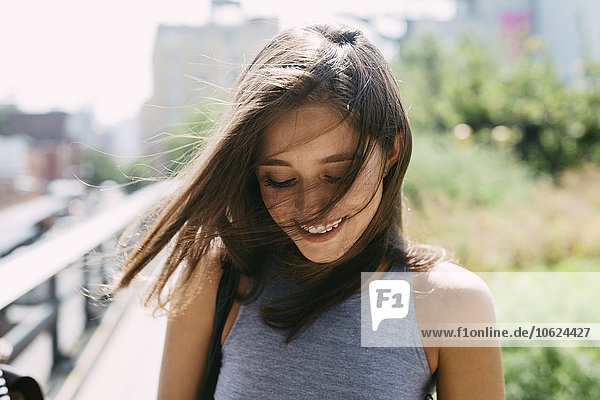 USA  New York City  lächelnde brünette junge Frau im Freien