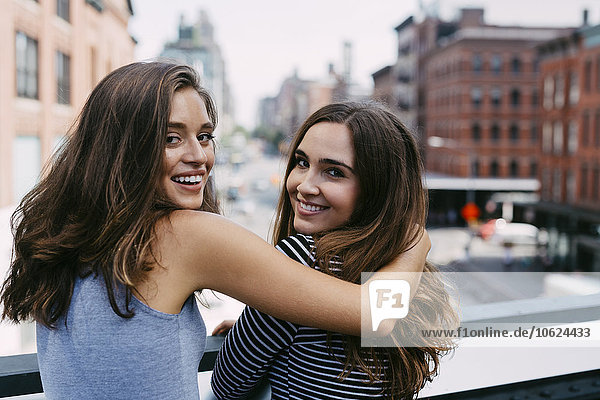USA  New York City  zwei Freunde  die sich in der Stadt umarmen