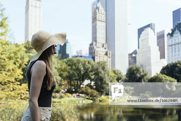 USA,  New York City,  junge Frau mit Sommerhut im Central Park