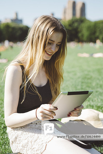 USA  New York City  junge Frau mit digitalem Tablett im Central Park