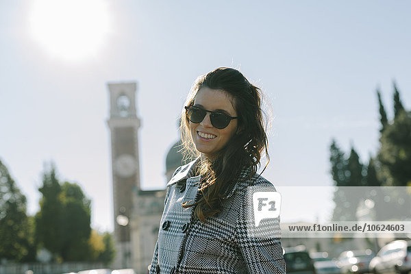 Italien  Vicenza  lächelnde brünette Frau mit kariertem Mantel und Sonnenbrille