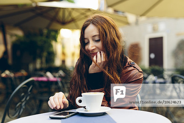 Woman having a coffee outdoors in a little bar