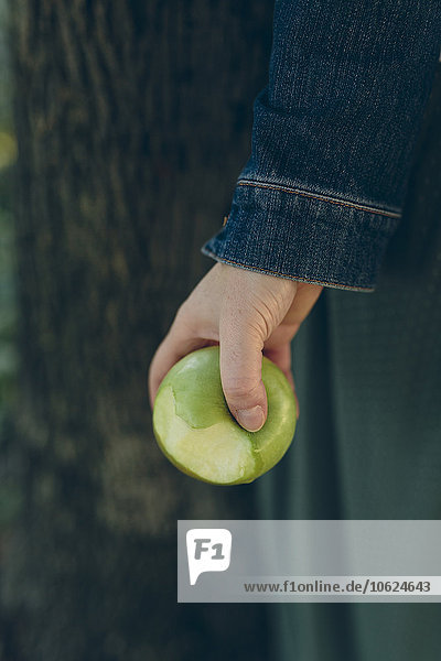 Hand hält einen grünen Apfel im Freien