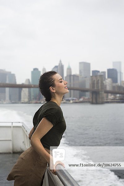 USA  New York City  young woman standing on an excursion boat on a windy day