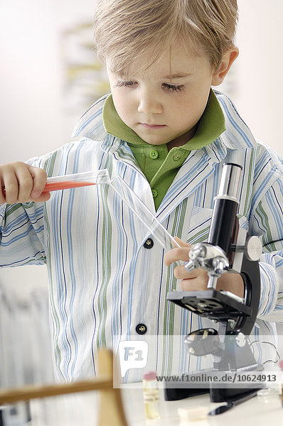 Portrait des kleinen Jungen mit Reagenzglas und Mikroskop