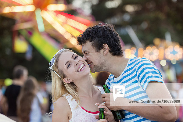 Glückliches Paar beim Jahrmarkt  Küssen und Trinken