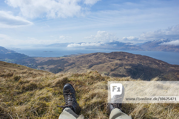 UK  Schottland  Schottische Highlands  Glencoe  ruhender Wanderer auf dem Gipfel eines Berges